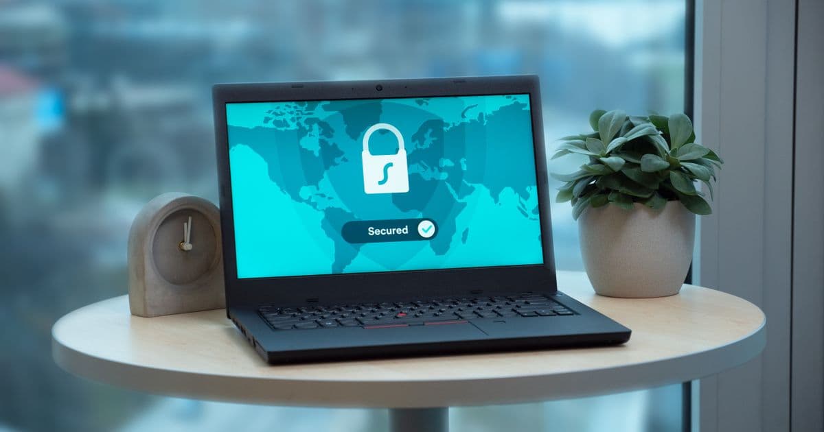 Persona protegiendo sus datos personales con un candado y un portátil al contratar IPTV