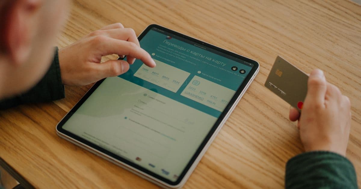 Persona pagando de forma segura con tarjeta y un método trazable junto a un portátil