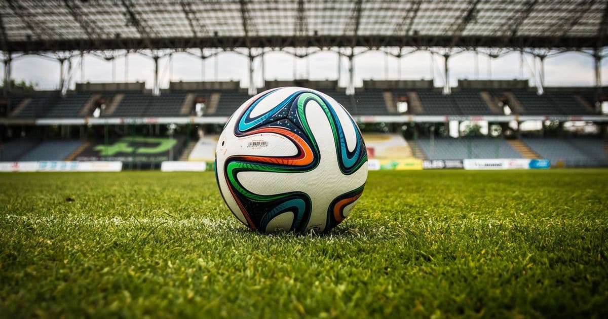 Estadio de fútbol iluminado de noche, símbolo del deporte en directo que se busca en apps como Sir TV
